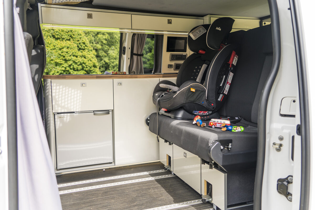 Kinderzitje in het laadcompartiment van een campervan, klaar voor een roadtrip